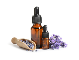 Bottles of essential oil and lavender flowers on white background