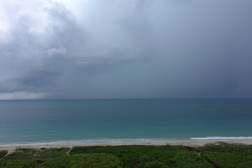 A storm over the colorful Atlantic Ocean with dark clouds.