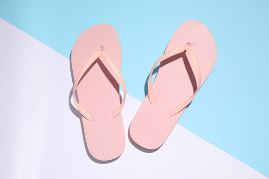Pair of stylish flip flops on color background, top view. Beach objects