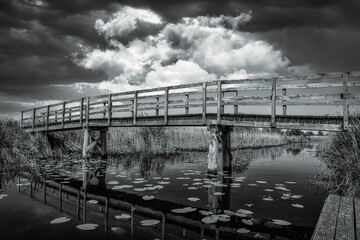 dramatischer Himmel über einer Holzbrücke