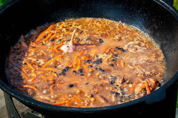 Hot pilaf in large cauldron outdoors. Tasty pilaf at street.