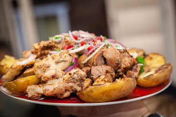 Grilled meat and vegetables on a plate close-up.