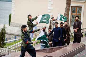 Group of pakistani man wearing traditional clothes salwar kameez or kurta with Pakistan flags.
