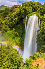 A long exposure view of a rainbow produced by the spray from upper waterfalls at Marmore, Umbria, Italy in summer