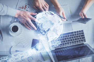 Double exposure of man and woman working together and world map hologram drawing. international network concept. Computer background. Top View.