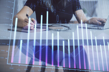 Double exposure of businesswoman hands typing on computer and forex chart hologram drawing. Financial analysis concept.