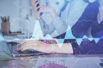 Multi exposure of woman hands typing on computer and financial graph hologram drawing. Stock market...
