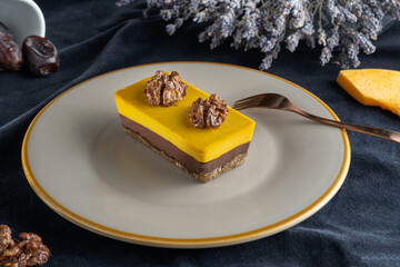 Homemade pumpkin pie with chocolate, and nuts. Decorated with walnuts. Laid on a plate, on the background of lavender-2.