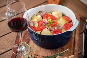 Codfish with tomatos, potatoes and a glass of wine