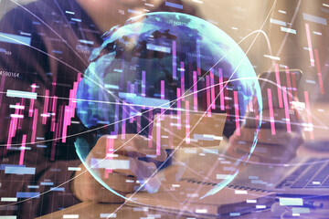 Double exposure of man's hands holding and using a phone and financial graph drawing. Analysis concept.