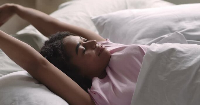 Well-slept african american woman waking up in her bed