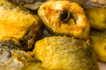 Pieces of navaga fish in batter, fried in oil in a pan.