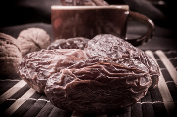 Big luxury dried date fruit on the bamboo mat, kurma ramadan kareem concept, close up.