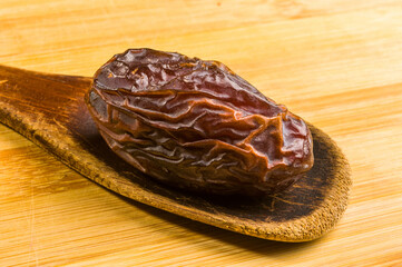 Big luxury dried date fruit on the wooden board, kurma ramadan kareem concept, close up.
