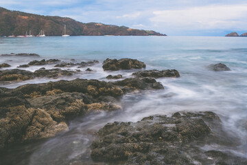 Beautiful dramatic long exposure seascape of waves against rocks 