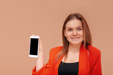 Naklejka premium A close-up portrait of a girl with loose hair shows a blank smartphone screen.