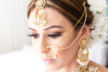 Beautiful female model wearing traditional Sikh wedding attire as she prepares for the ceremony