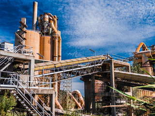 Cement Mill. Old Industrial production building. Cloudy blue sky.