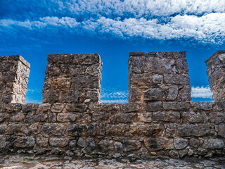 Sesimbra Medieval Castle Battlements. Ancient Moorish defensive wall in Portugal. Blue Cloudy Sky
