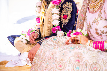 Sikh bride and groom next to each other during marriage ceremony in traditional wedding attire