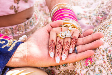 Sikh bride and groom holding hands after exchanging rings