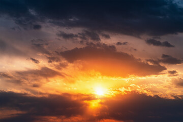 Naklejka na ściany i meble Bright dramatic sunset sky background. Beautiful colorful cloudscape with sun light.
