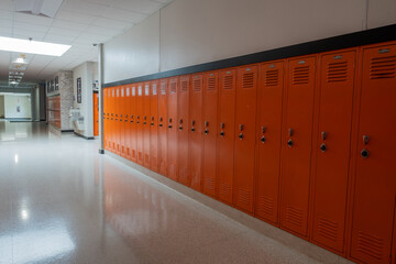Empty hallway in school lined with orange lockers