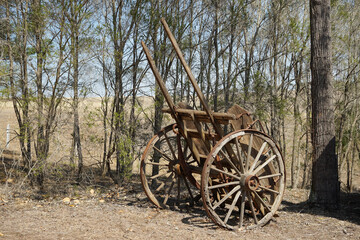 Fototapeta na wymiar Old weathered wooden farm cart in a rural setting with trees and hill in the background. Queensland Australia 
