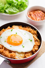 Kimchi fried rice with fried egg on top in small cooking pan, Korean food