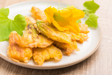 Crunchy fried pumpkin flowers on plate, edible flower, Vegan snack
