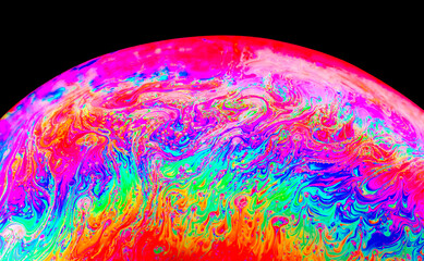 Rainbow colors created by soap, bubble,or oil on black background
