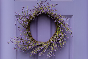 Photograph of a seasonal summer wreath on a lavender colored door
