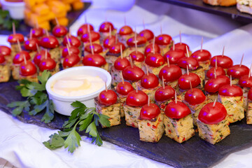 Fototapeta na wymiar canapes decorated with cherry tomatoes and parsley on frua buffet table