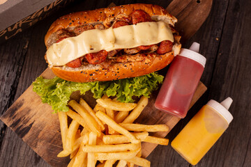 Hot dogs on wooden table with wild potatoes and sauce