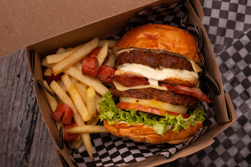 double meat burger in its packaging with french fries