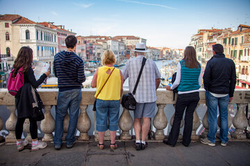 Tourists stand on a footbridge overlooking the famous Grand Canal in Venice, Italy.
