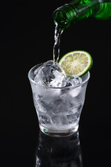 グラスに焼酎を注ぐ