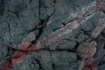 dark gray stone texture with cracks and large veins of red stone