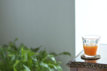 put a fruit juice on a antique mahogany table. window is bright.  This expensive furniture is made in England.  blurred background with copy space.