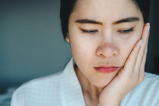 Portrait of Asian woman suffering from toothache. Toothaches can be caused by something happening to your teeth or gums.