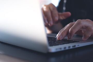 close up of man hand typing on laptop computer keyboard