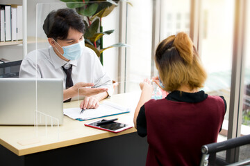 Obraz premium Asian male employees worked in offices during the outbreak of the coronavirus (COVID-19).