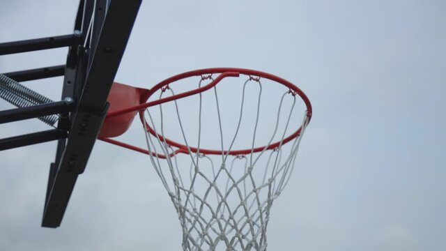 Basketball Hoop In The Court Under The Bright Blue Sky.  - pan down