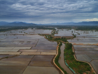 Aerial view of farmland with river flowing as source of water