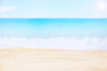Fototapeta na wymiar Blurred blue sea and sand beach, selective focus on sand for product display