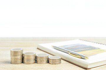 Notepad and coins with credit card on table