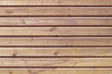 Obraz premium A close-up of a fragment of a wall made of horizontal strug wooden planks. Horizontal orientation, front view. Selective focus. Wooden texture, background.