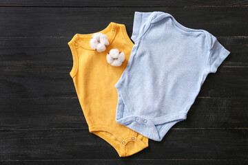 Cotton baby clothes on wooden background