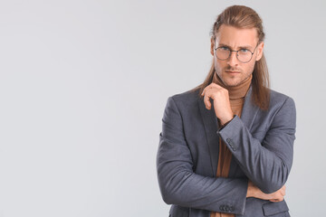 Handsome man with stylish hairdo on light background