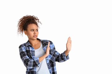 Scared African-American woman on white background. Stop racism